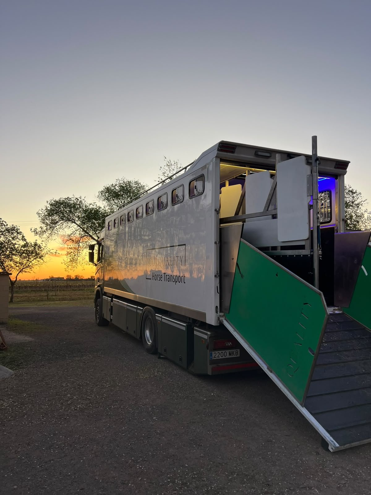 Camión de transporte de caballos de YQHT con la rampa bajada al atardecer